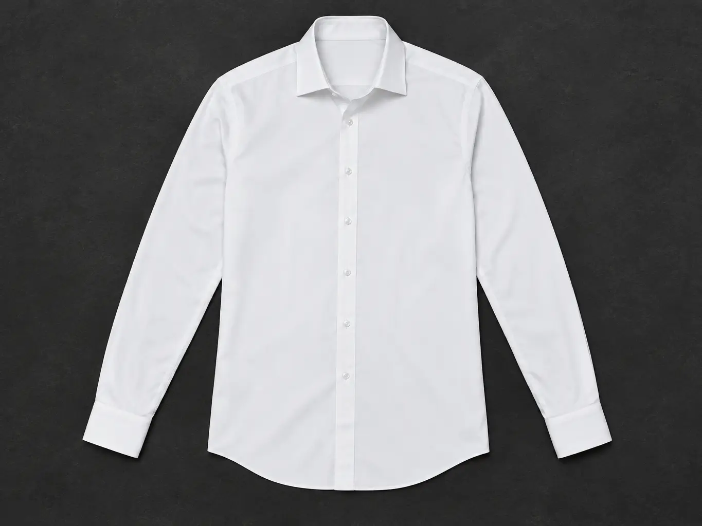 Camisa blanca de vestir extendida sobre una mesa oscura